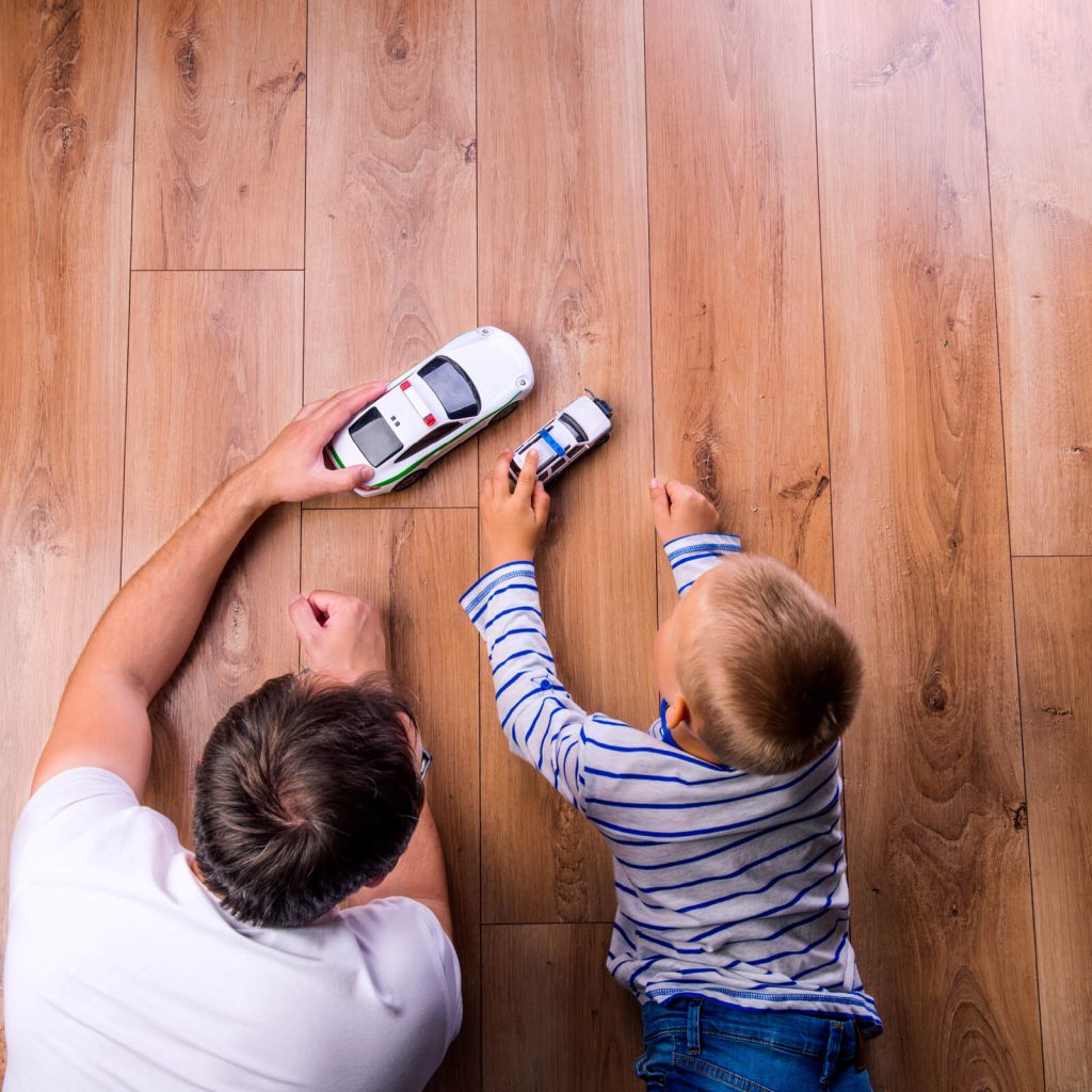 Father and kid playing with toycars on Hardwood floor | Bram Flooring